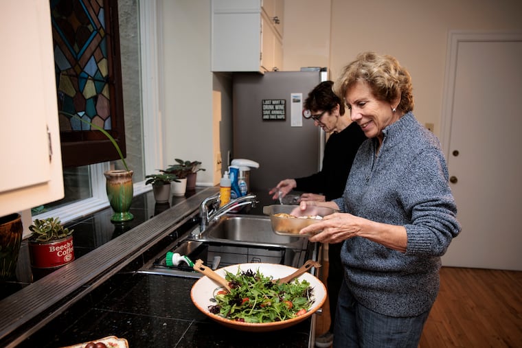 Susan Dannenberg and Michele Mathes prepare dinner in their kitchen. They're learning to meld their lives after years of living alone.