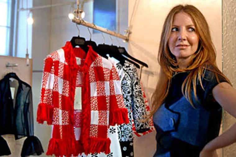 Designer Paula Hian in her Manayunk studio with some of her new line of knits, including the outfit she is wearing. (Tom Gralish / Staff)