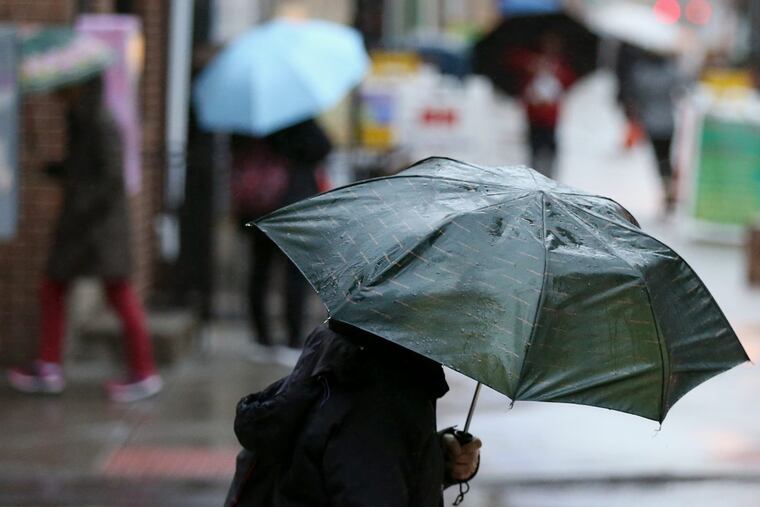 A pedestrian carries an umbrella under light rain in Chinatown earlier this year.