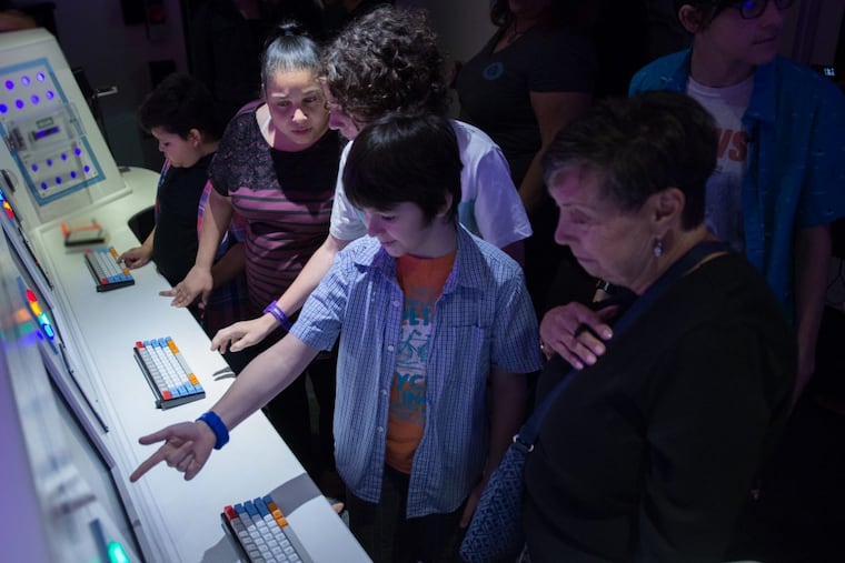 Visitors try to navigate the Intergalactic Escape room at the Franklin Institute.