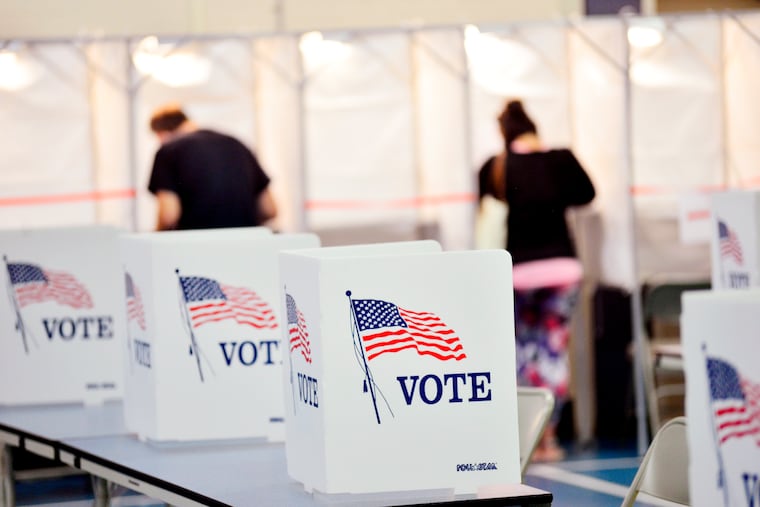 In this Sept. 8, 2020 photo, voting booths are kept socially distant at the Chesterfield, N.H. polling site. A majority of President Donald Trump’s supporters plan to cast their ballot on Election Day, while about half of Joe Biden’s backers plan to vote by mail. That's according to a new poll from The Associated Press-NORC Center for Public Affairs Research that finds 54% of voters say they will vote before polls open on Nov. 3.