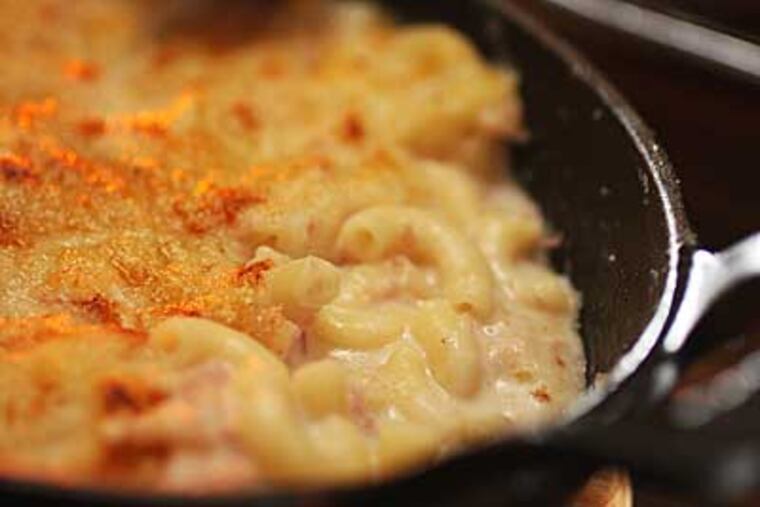 At 10 Arts, chef de cuisine Jennifer Carroll, inspired by her mother's recipe, creates a creamy mac and cheese studded with ham and covered with a Gruyère crust and sourdough bread crumbs. (MICHAEL BRYANT / Staff Photographer)