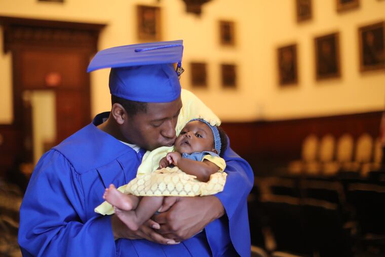 Kasim Shaw, 20, graduates from a diversionary program with his daughter Sevyn Brandice Hunter Shaw, at City Hall. Friday June 1, 2018 DAVID SWANSON / Staff Photographer