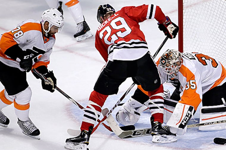 Flyers right wing Pierre-Edouard Bellemare and goalie Steve Mason keep Blackhawks left wing Bryan Bickell from getting a shot on goal during the second period. (Charles Rex Arbogast/AP)