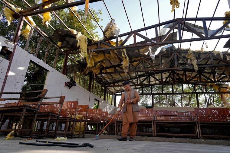 A man cleans a Hazara education center that was destroyed in Friday's suicide bombing in Kabul, Afghanistan.