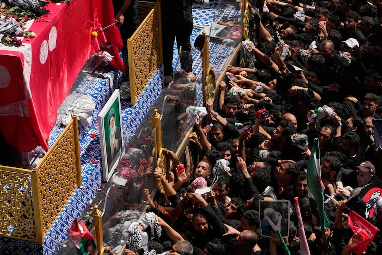 Mourners reach toward a truck carrying the coffin of Iranian Supreme Leader Ayatollah Ali Khamenei during a funeral procession in Najaf, Iraq, Wednesday, July 8, 2026.