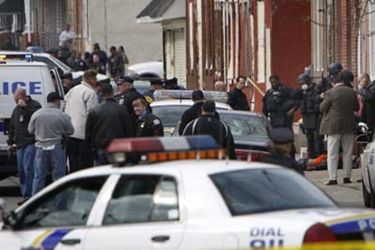Investigators crowd the scene of a shootout near 11th Street and Indiana Avenue in North Philadelphia on Thursday that left a police officer wounded and the gunman dead. (David Maialetti / Staff Photographer)