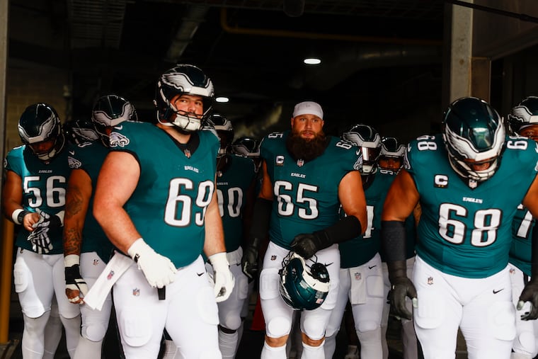 Eagles tackle Lane Johnson (center) and the offensive linemen take the field before Sunday's game against Tampa Bay.
