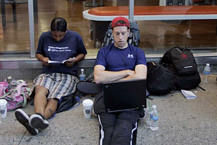 Sam Fort from Philadelphia waits in line at 7 a.m. with Lakita Seldon from South Philadelphia at the AT&T store at 16th and Ranstead Streets in Philadelphia. Fort had been in line since 4:30 am. (LAURENCE KESTERSON / Inquirer)