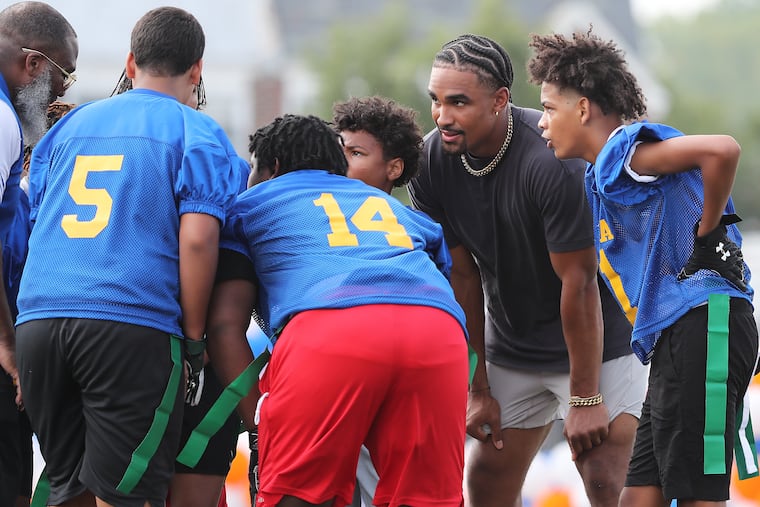 Philadelphia Eagles quarterback Jalen Hurts joins a huddle with students from Middle Years Alternative school during a flag football game as he visits Benjamin L Johnston Memorial Stadium in Philadelphia, Pa. on Sunday, Aug. 28, 2022. Hurts and Kellogg’s Tony the Tiger announce a donation from Mission Tiger to the School District of Philadelphia. The donation will fund three new middle school Rookie Tackle program teams and start a new girls’ flag football program at six middle schools.
