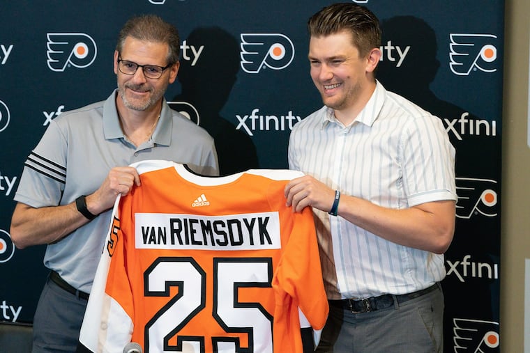 Ron Hextall, left, and left winger James van Riemsdyk are shown during a news conference after he signed with the team this summer. Van Riemsdyk's injury has left a major void in the team's identity.