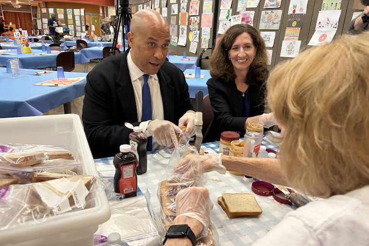 Sen. Cory Booker gets tips on making peanut butter and jelly sandwiches and chats with volunteers at Cathedral Kitchen in Camden on Thursday, Aug. 27.
