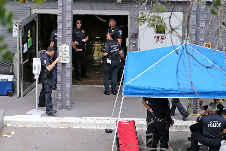 FILE - A Sept. 13, 2017 file photo shows a police staging area at the south entrance of the Rehabilitation Center at Hollywood Hills where residents died, in Hollywood, Fla. Defense attorneys said Sunday, August 25, 2019 that arrests are expected shortly in the case of the Florida nursing home where 12 elderly patients died after the complex lost power and was engulfed by sweltering heat during the powerful 2017 Hurricane Irma.(Charles Trainor Jr./Miami Herald via AP, File)