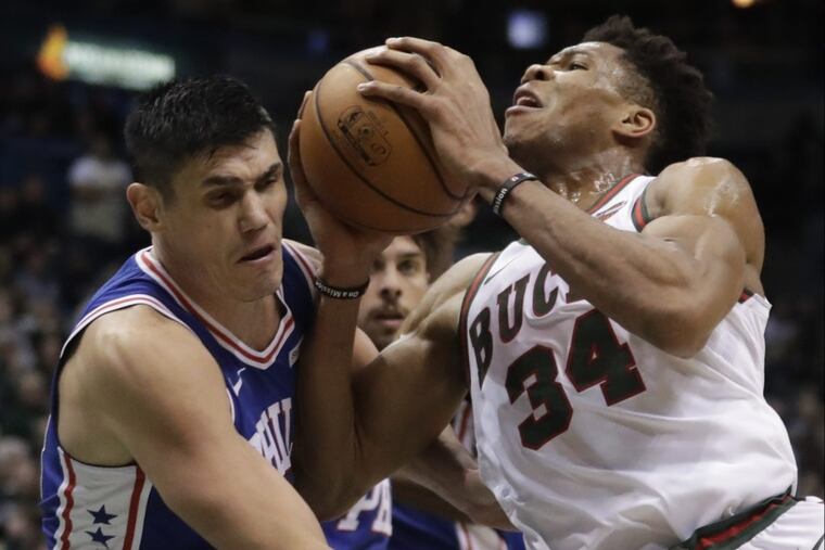 The Sixers’ Ersan Ilyasova fouls the Bucks' Giannis Antetokounmpo during the second half.
