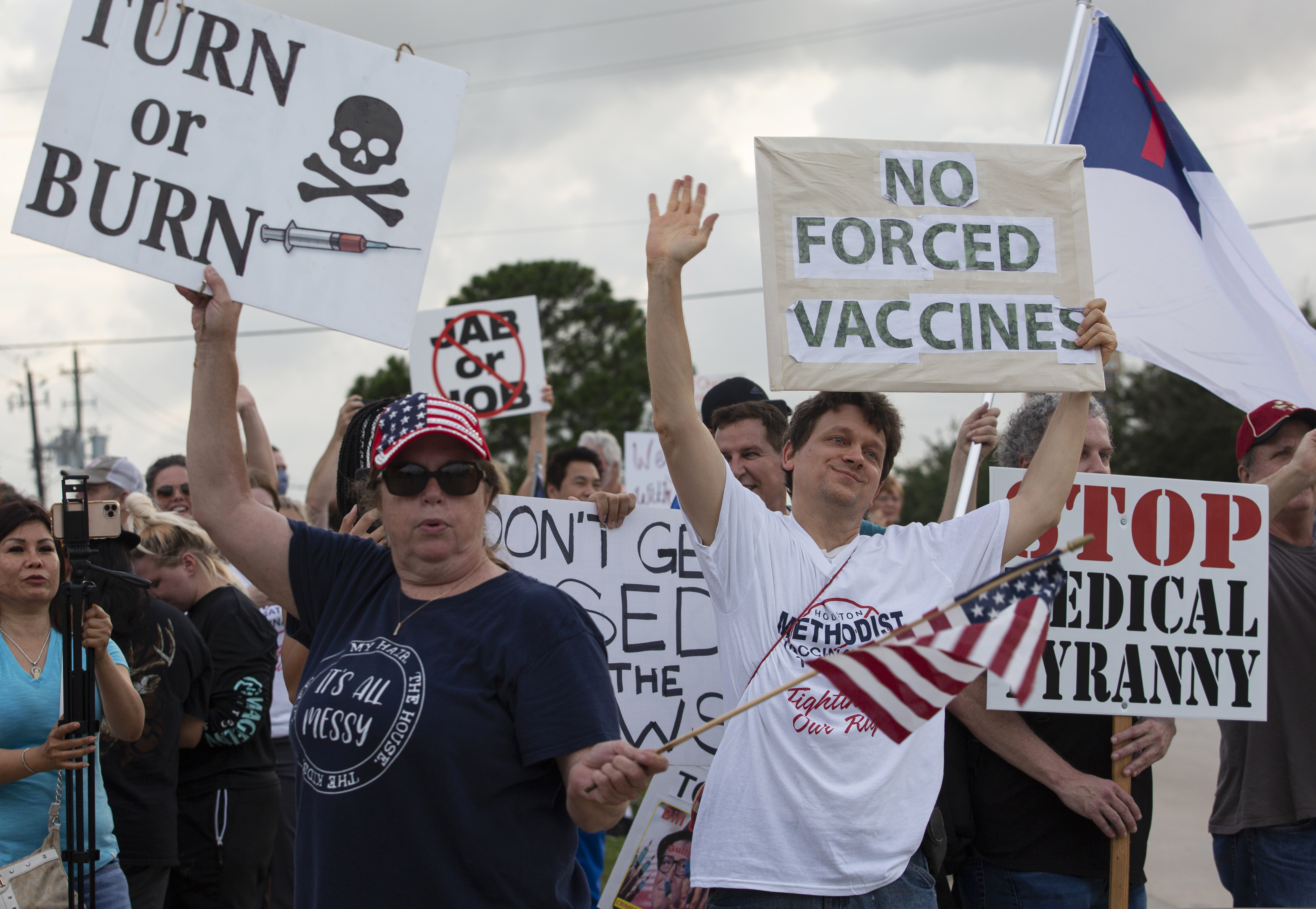 Demonstrators at Houston Methodist Baytown Hospital in Baytown, Texas, on June 7, 2021, wave at cars that honk at them to support their protest against a policy that says hospital employees must get vaccinated against COVID-19 or lose their jobs. A federal judge dismissed their lawsuit, saying if workers don’t like the rule, they can go find another job.