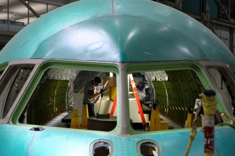 Mechanic Ryan Schutt works on a Boeing 767 at the plantin Everett, Wash. Some military contractors remain busy.