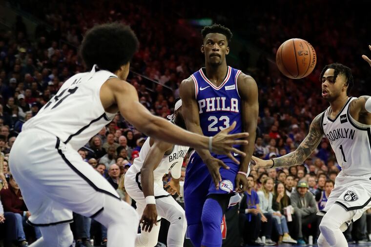 Sixers guard Jimmy Butler (23) passing the basketball past Brooklyn Nets guard D'Angelo Russell (right) and center Jarrett Allen, has taken it upon himself to get teammates involved.