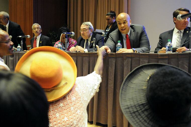 Sen. Cory Booker, D-N.J., reaches outto shake an attendee’s hand. U.S. Rep. Chaka Fattah (below) speaks yesterday. (MICHAEL PRONZATO / STAFF PHOTOGRAPHER)