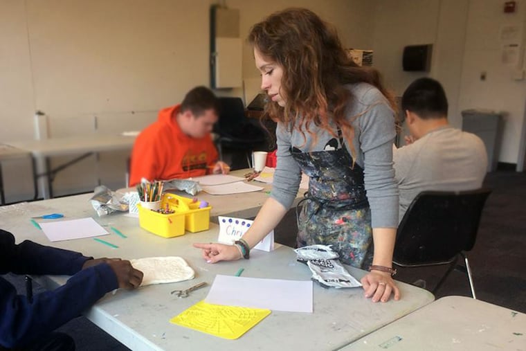 Emily Eggly, a Moore College of Art & Design senior, works with special-needs students in her “Special Populations” art class.