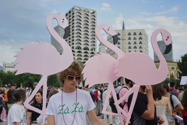 Protesters hold pink flamingo cutouts during a demonstration in Tirana, Albania, Wednesday, June 3, 2026, opposing a luxury coastal development project linked to Jared Kushner and Ivanka Trump over concerns about environmental impacts and transparency.