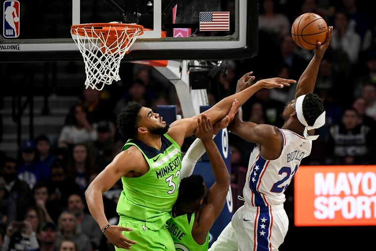 Jimmy Butler (right) draws contact from the Timberwolves' Karl-Anthony Towns (left) and Josh Okogie during the first half.