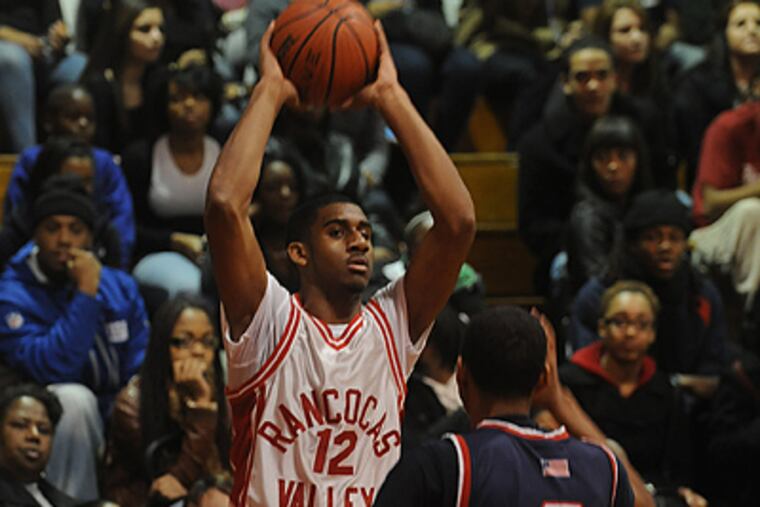 Kenny Johnson of Rancocas Valley looks to pass the ball with Willingboro's Dominic Cain defending. (Bob Williams /For The Inquirer)