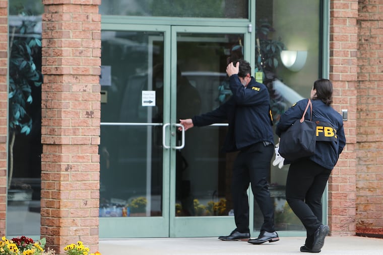 FBI personnel enter a building Wednesday in Portsmouth, Va.