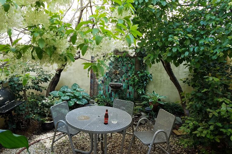 The private back yard with a fountain at the townhouse for sale in Philadelphia's Queen Village neighborhood.