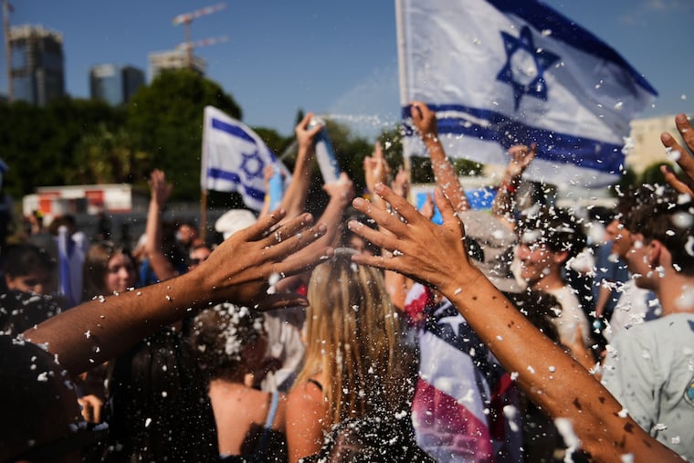 People wave Israeli flags and spray foam in celebration after the arrival of freed hostages at Beilinson Hospital in Petah Tikva, Israel, following their release from Hamas captivity in the Gaza Strip on Monday.