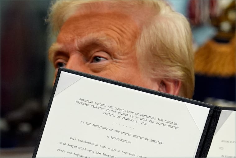 President Donald Trump signs an executive order pardoning about 1,500 defendants charged in the Jan. 6, 2021, attack on the U.S. Capitol, in the Oval Office on the first day of his second term in January.