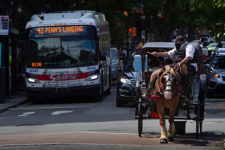 A carriage tour operator gives patrons a slow carriage ride along Chestnut Street at Sixth Street in 2020.