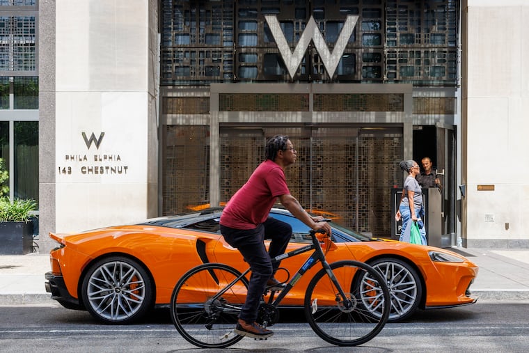 McLaren Orange sports car and bicycle in front of W Philadelphia Hotel at W Philadelphia in 2024.