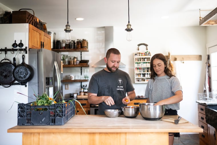 Danny Childs (left) and his wife Katie sift through tomatoes picked from their garden at their home in Pennsauken, N.J. The couple plans to open Field Day — their first cocktail bar — in Northern Liberties in September 2026.