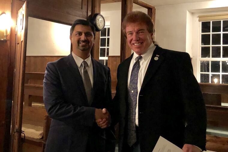 Chesterfield Township Committeeman Shreekant Dhopte (Left) and former Committeeman Sam Davis (right) shake hands at the Crosswicks Friends Meeting in Chesterfield Tuesday night.