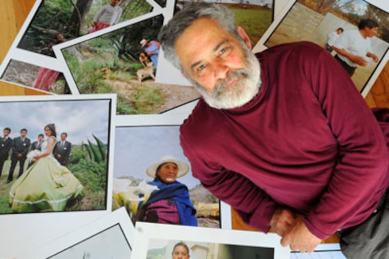 Visual documentarian Laurence Salzmann in his studio amid some of the dozens of photos he captured in Mexico that are part of the "De Pueblo a Pueblo," or From Town to Town, a six-week, first-of-its-kind celebration of Mexican culture in venues across Philadelphia beginning April 26, 2012. ( Clem Murray / Staff Photographer )