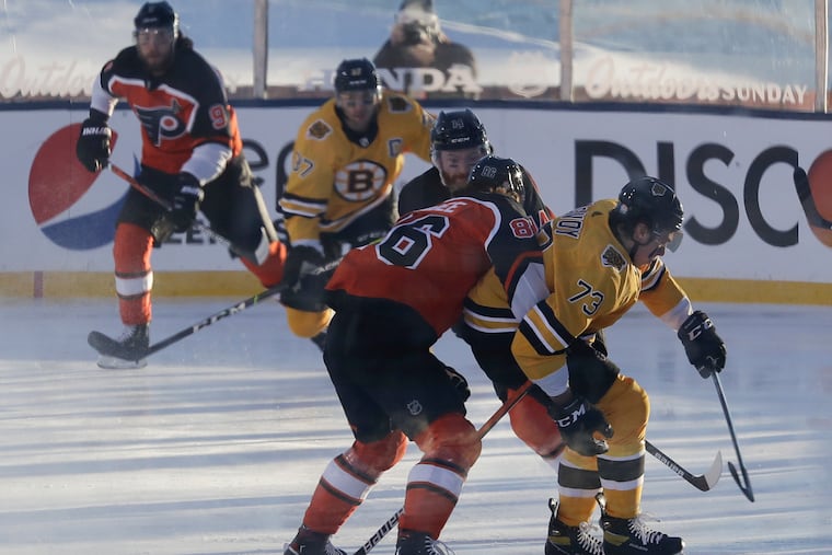 Flyers winger Joel Farabee (left) defends Boston Bruins defenseman Charlie McAvoy during the first period in an outdoor NHL game on the 18th fairway of the Edgewood Tahoe Resort in Nevada. Farabee scored the Flyers' first goal in their 7-3 loss.