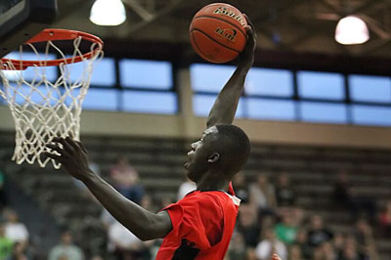Imhotep's Brandon Austin slam dunks over Holy Cross's Casey Gaughan. (Steven M. Falk/Staff Photographer)