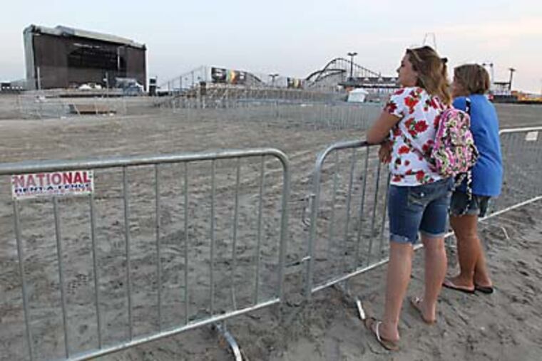 Tori Nazar, 12, left, and her mother, Michelle Nazar, right, both from Pennsville linger at the outskirts of the gates set up to keep people out of the venue until tomorrow's concert by Kenny Chesney on the beach at Wildwood, NJ. ( MICHAEL BRYANT / Staff Photographer )