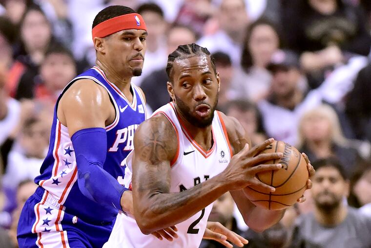 Philadelphia 76ers forward Tobias Harris, left, watches as Toronto Raptors forward Kawhi Leonard (2) moves the ball during the first half of Game 1 of a second-round NBA basketball playoff series in Toronto, Saturday, April 27, 2019. (Frank Gunn/The Canadian Press via AP)