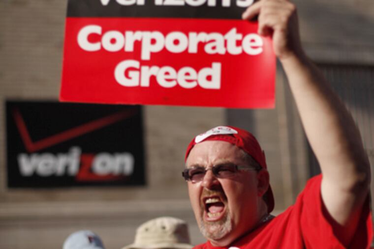 Verizon workers picket outside company offices Monday in Phila. Some consumers have reported vandalism since the strike started. (Matt Rourke / AP Photo)