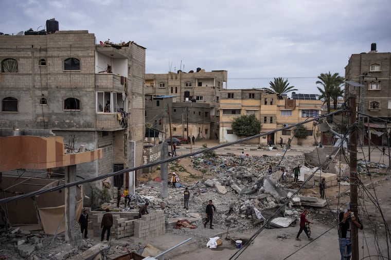 Palestinians inspect the rubble of the Hasouna family house, which was struck by an Israeli airstrike during an operation to rescue two hostages in Rafah, southern Gaza Strip on Tuesday.