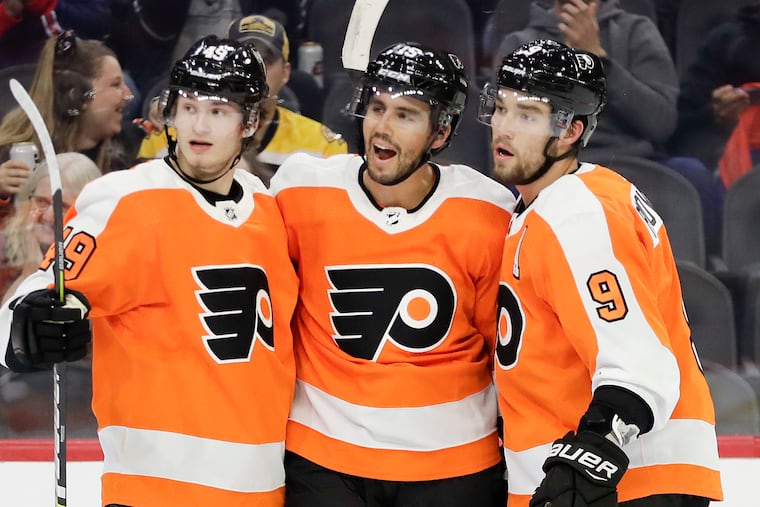 Joel Farabee (left) celebrates a goal by Matt Niskanen (center) with the defenseman and Ivan Provorov (right) in a preseason game against Boston. Farabee made his NHL debut Monday against Vegas.