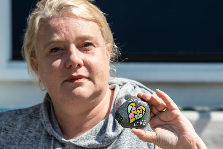 Amy Coady holds a small rock, painted with an uplifting message, at her home in Audubon, N.J. Coady started the Kindness Rocks Audubon group that paints small, smooth rocks with uplifting messages and hides them around town for other folks to find and post on their Facebook page. It's very popular in the little town.