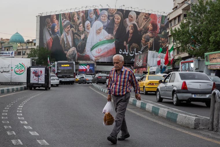 A man crosses a street near Enghelab Square in Tehran, on Sunday, May 24, 2026. The United States and Iran have agreed in principle to a deal that would wind down the war in the Middle East by reopening the Strait of Hormuz and by committing Iran to dispose of its highly enriched uranium, a senior U.S. official told reporters on Sunday.