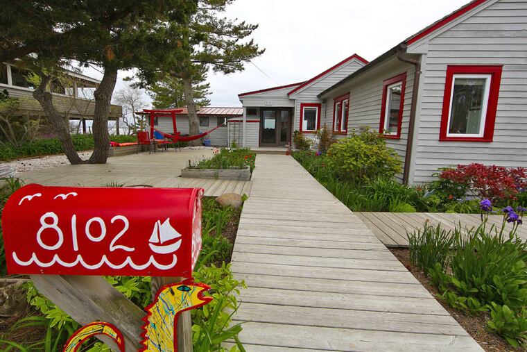 The brightly painted mailbox and boardwalk path to the door hint that this Long Beach Island house is no ordinary seashore home.