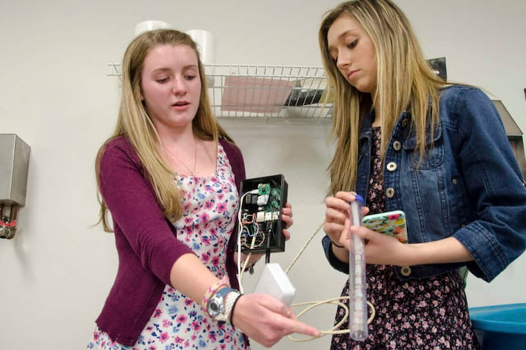 Kate Pelcin (left) and Kristina Griste work on the Aqua Tweeter, a flood-detection device they helped develop at Downingtown High School West.