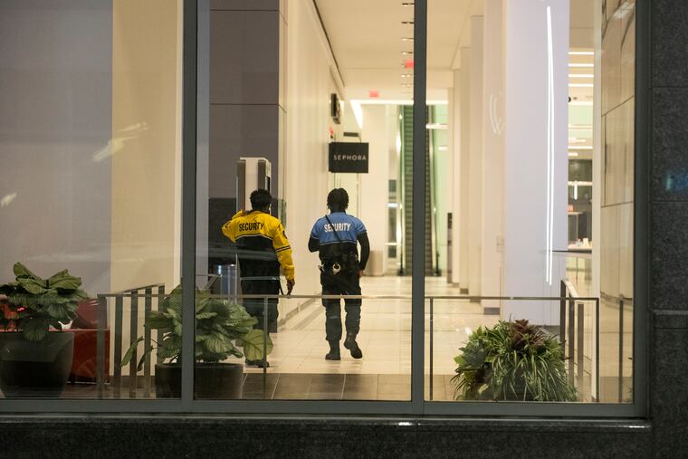 Security patrols the empty Fashion District in Center City on Tuesday. Shots were fired forcing the Fashion District to close early along East Market Street in Philadelphia. A teen was arrested.