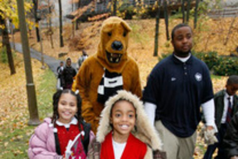 Accompanied by the Nittany Lion, Nachae Collins (center) and fellow third-graders at First Philadelphia Charter School tour the campus of Penn State Abington.