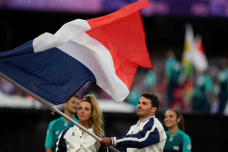 Athletes wave a French flag during the 2024 Summer Olympics closing ceremony at the Stade de France, Sunday, Aug. 11, 2024, in Saint-Denis, France.
