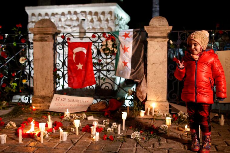 A child stands alongside candles during a vigil at the site of Tuesday's suicide bombing that killed 10 foreigners and wounded 15 other people in the historic Sultanahmet district of Istanbul.